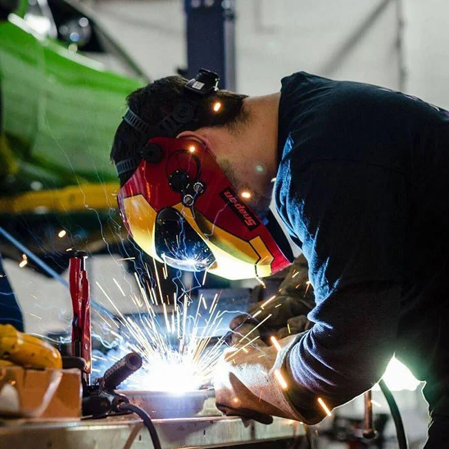 An auto mechanic welding car parts